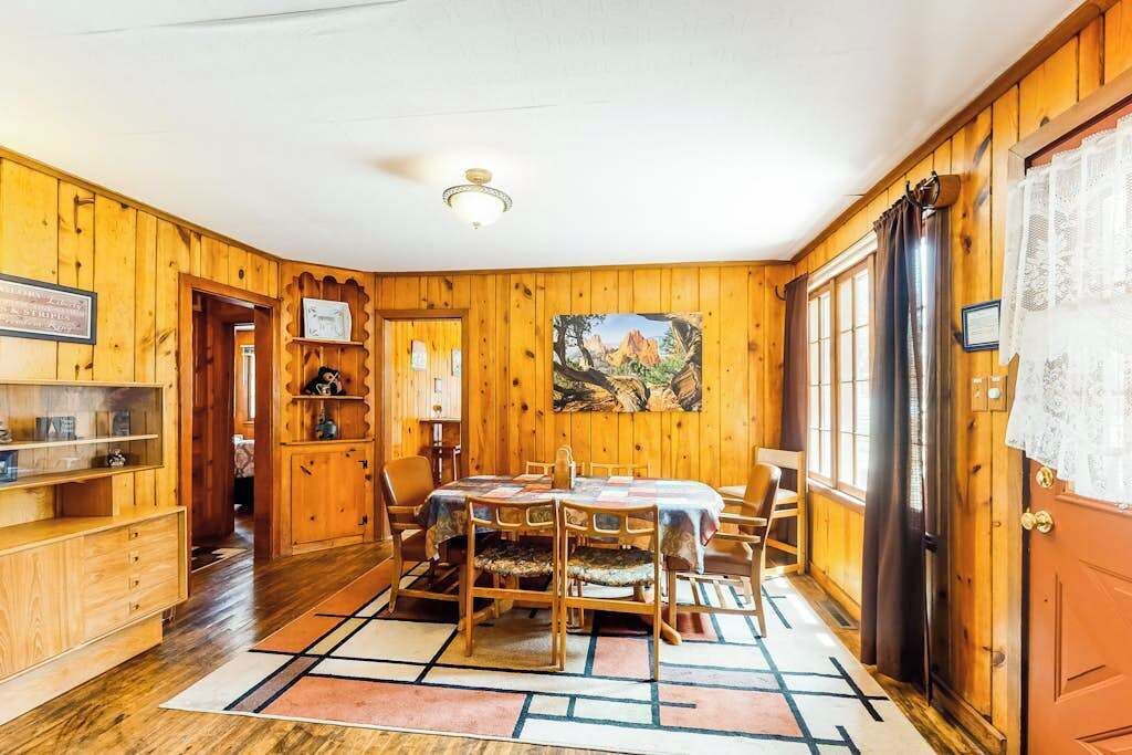 Ein Holzinserieur mit einem Esstisch, Stühlen und einem Bild an der Wand.