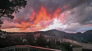 A sunset view over a town with buildings and a bridge.