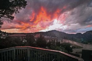 Une vue sur le coucher de soleil au-dessus d’une ville avec ses bâtiments et son pont.