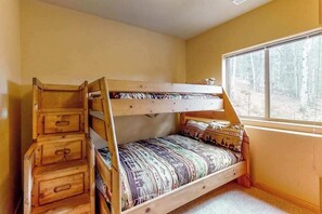 A bunk bed with drawers and a window with a forest view. - Dog-Friendly Cabin | Hot Tub & Mountain Views (Divide)