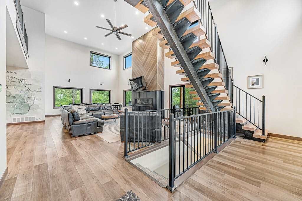 Un interior moderno con una escalera de caracol, una chimenea y una zona de estar con un mapa en la pared.