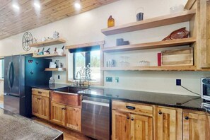 Eine Küche mit Holzschränken, einem Edelstahl-Kühlschrank und einem Geschirrspüler.