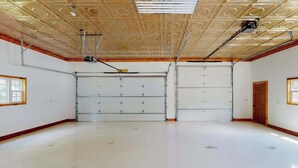 Ein großer, leerer Raum mit hoher Decke und einer Garagentür.