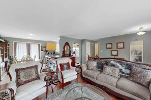 A living room with a sofa, armchairs, a coffee table, and a dining area with a table and chairs. - Dog-Friendly 3BR • Two Decks • Fireplaces (Colorado Springs)