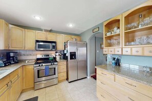 A kitchen with wooden cabinets, stainless steel appliances, and a built-in wine rack. - Dog-Friendly 3BR • Two Decks • Fireplaces (Colorado Springs)