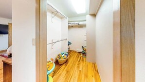 A narrow hallway with wooden flooring, a ceiling fan, and a child's play area with toys and a small table. - Skyline Ridge - Secluded Retreat • Stunning Views & Loft (Florissant)