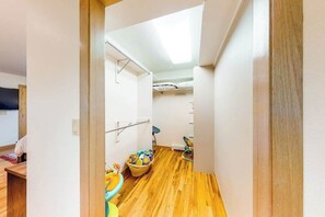 A narrow hallway with wooden flooring, a ceiling fan, and a child's play area with toys and a small table. - Skyline Ridge - Secluded Retreat • Stunning Views & Loft (Florissant)