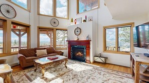 A spacious living room with a fireplace, large windows, and a high ceiling. - Skyline Ridge - Secluded Retreat • Stunning Views & Loft (Florissant)