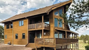 A multi-story wooden building with balconies, large windows, and a sloped roof. - Skyline Ridge - Secluded Retreat • Stunning Views & Loft (Florissant)