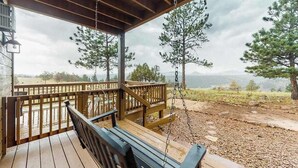 A wooden deck with a swing, overlooking a mountainous landscape. - Skyline Ridge - Secluded Retreat • Stunning Views & Loft (Florissant)