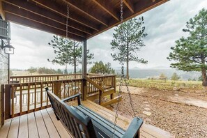 A wooden deck with a swing, overlooking a mountainous landscape. - Skyline Ridge - Secluded Retreat • Stunning Views & Loft (Florissant)