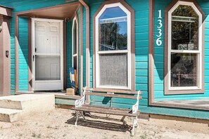 A house with a front door, a bench, and a window with the number 1336. - Rocky Mountain Rustic - Mountain-View Home • AC & Fast WiFi (Colorado Springs)