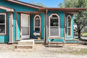 A single-story house with a front porch, a door, and two windows. - Rocky Mountain Rustic - Mountain-View Home • AC & Fast WiFi (Colorado Springs)