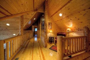 A wooden interior with a central hallway leading to a bedroom. - Log Lodge by Terry Peak • Hot Tub & Game Room (Lead)