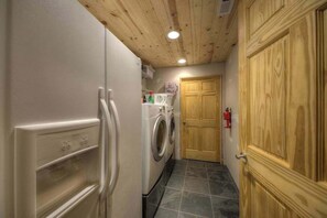 Eine kleine Küche mit Kühlschrank, Waschmaschine und Holzausstattung.