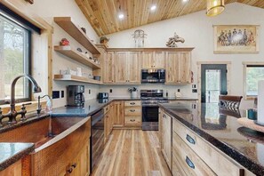 A modern kitchen with wooden cabinets, stainless steel appliances, and a granite countertop. - Bear Butte Hideaway - Secluded Hideaway w/ Private Hot Tub (Deadwood)