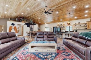 A spacious living area with leather sofas, a wooden coffee table, and a patterned rug. - Bear Butte Hideaway - Secluded Hideaway w/ Private Hot Tub (Deadwood)