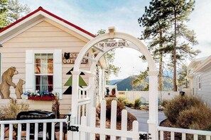 A house with a sign reading 'The Twilight Zone' and a white picket fence. - Cub Cottage - Cozy Tiny Home • Mtn View, Dogs OK (Woodland Park)