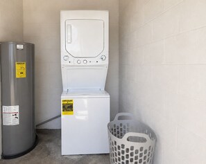 A compact laundry area with a washing machine and a water heater. - Relaxing Melbourne Home Away from Home (Melbourne)