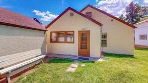 A single-story building with a sloped roof, a front door, and a small porch area. - Miners Cottage - Cozy Cottage • Fireplace Near Deadwood (Lead)