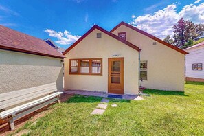 A single-story building with a sloped roof, a front door, and a small porch area. - Miners Cottage - Cozy Cottage • Fireplace Near Deadwood (Lead)
