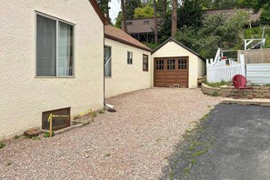 Ein Wohnhaus mit Schotterauffahrt, Garage und umzäunter Garten.