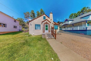 A single-story house with a front porch and a green door. - Miners Cottage - Cozy Cottage • Fireplace Near Deadwood (Lead)