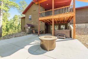 A wooden cabin with a balcony, outdoor seating, and a hot tub. - Klassy Lodge - Private Hot Tub & Game Room (Sturgis)