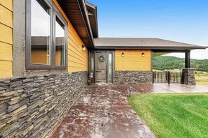 A residential building with a stone foundation, a wooden exterior, and a covered porch. - Cedar Lodge on 17- Hot Tub Home Near Mt Rushmore (Sturgis)