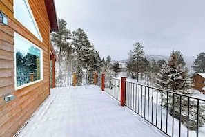 A wooden building with a balcony and a metal railing.