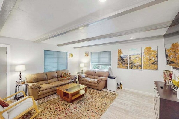 A living room with two sofas, a coffee table, and a patterned rug. - The Lookout at Woodland Park - Dog-Friendly Mtn Home • Fenced Yard (Woodland Park)