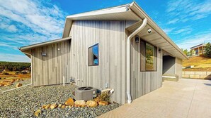 Et moderne hus med skråt tag, stort vindue og en stensokkel.