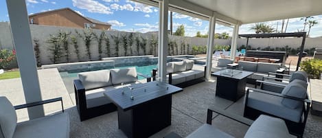 Ulkoterassi, jossa on uima-allas, oleskelualueita ja pergola.