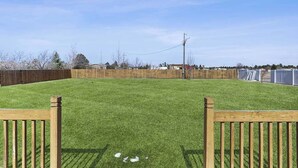 A fenced backyard with a wooden gate, a clear sky, and a wooden fence. - Stratobowl Escape - Dual-Unit Home Near Black Hills Fun (Rapid City)