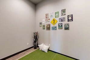 Ein Flur mit einer Golfausrüstungstasche und Kissen, an der Wand verschiedene golfbezogene Schilder.