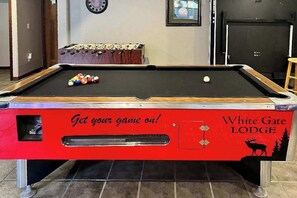 Una mesa de billar con borde rojo y la inscripción 'Get your game on!' y 'White Gate Lodge'.