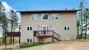 A two-story building with a front porch and a small deck. - Boxelder Bluff - Secluded Home • Mountain Views (Rapid City)