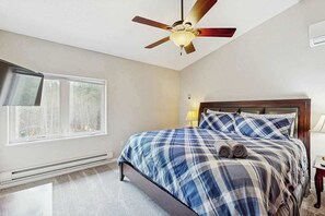 A bedroom with a bed, a ceiling fan, a window, and a nightstand. - Boxelder Bluff - Secluded Home • Mountain Views (Rapid City)