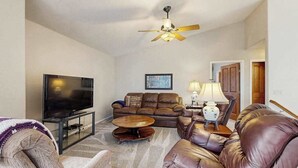 A living room with a flat-screen TV, leather sofas, a coffee table, and a ceiling fan. - Boxelder Bluff - Secluded Home • Mountain Views (Rapid City)