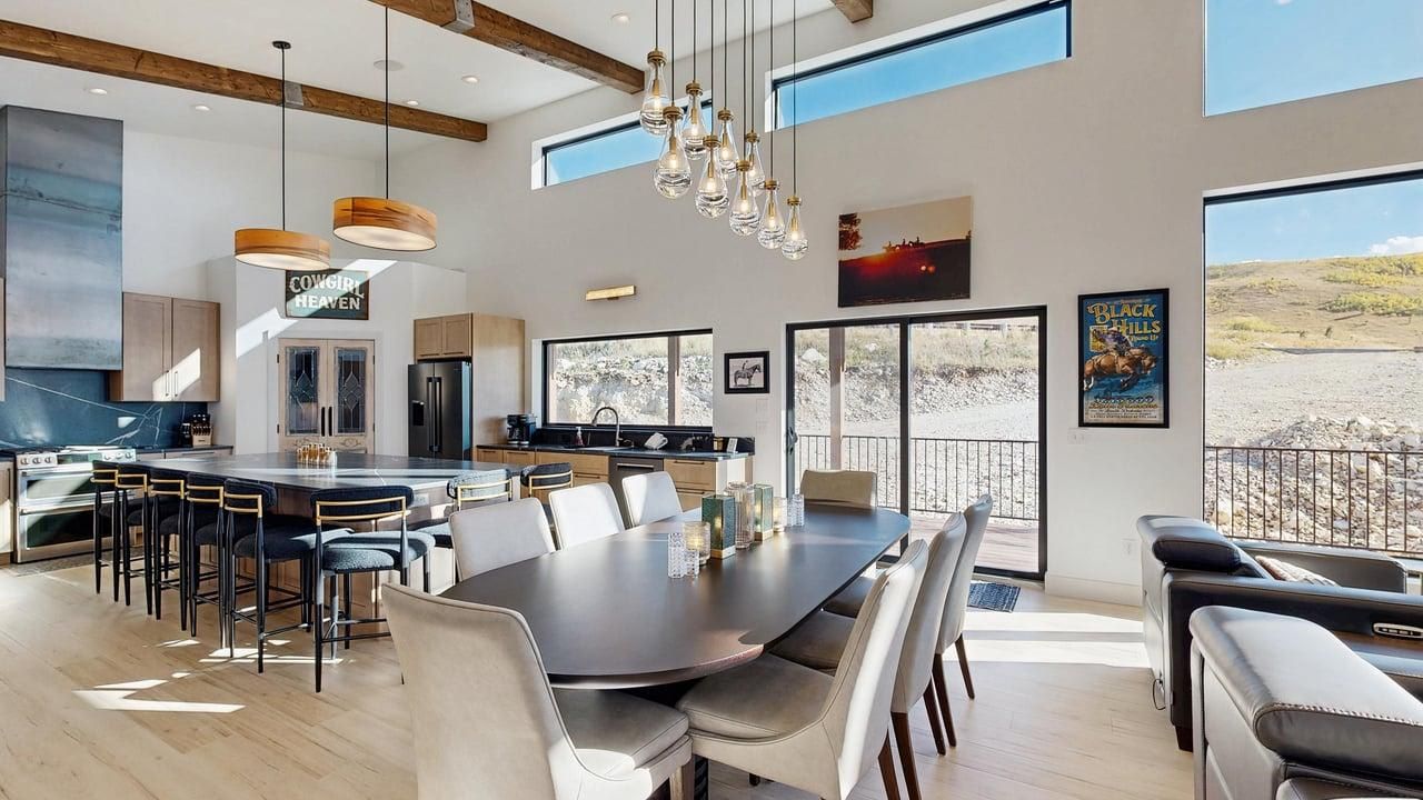 Een moderne keuken met een groot eiland, een zithoek met stoelen en uitzicht op de omgeving.