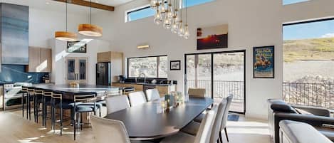 Een moderne keuken met een groot eiland, een zithoek met stoelen en uitzicht op de omgeving.
