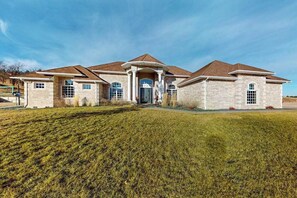 A two-story house with a central entrance, a covered porch, and a well-maintained lawn.