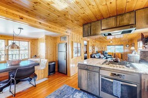 Ein Holzblockhaus-Interieur mit Küche, Essbereich und Wohnraum.
