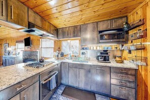 Eine moderne Küche mit Granit-Arbeitsplatten, Edelstahlgeräten und Holzschränken.