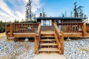 Eine Holzjagdhaus mit Veranda und Treppe zum Eingang.