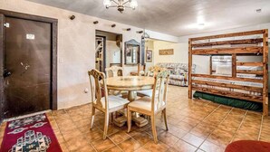 A dining area with a round table, chairs, and a chandelier. - Pikes Peak Retreat - Cabin w/ Pikes Peak & Forest Access (Divide)