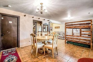 A dining area with a round table, chairs, and a chandelier. - Pikes Peak Retreat - Cabin w/ Pikes Peak & Forest Access (Divide)