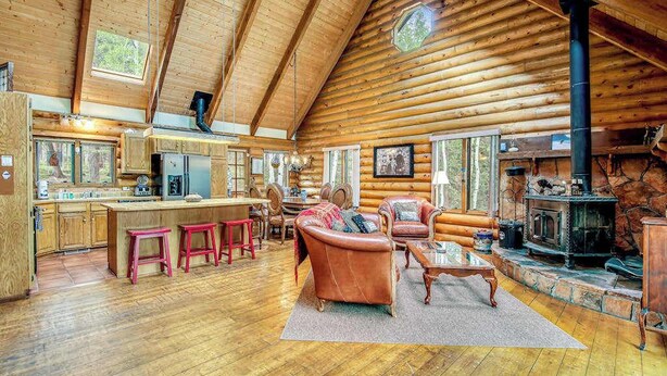 A log cabin interior with a kitchen, dining area, and living room. - Pikes Peak Retreat - Cabin w/ Pikes Peak & Forest Access (Divide)