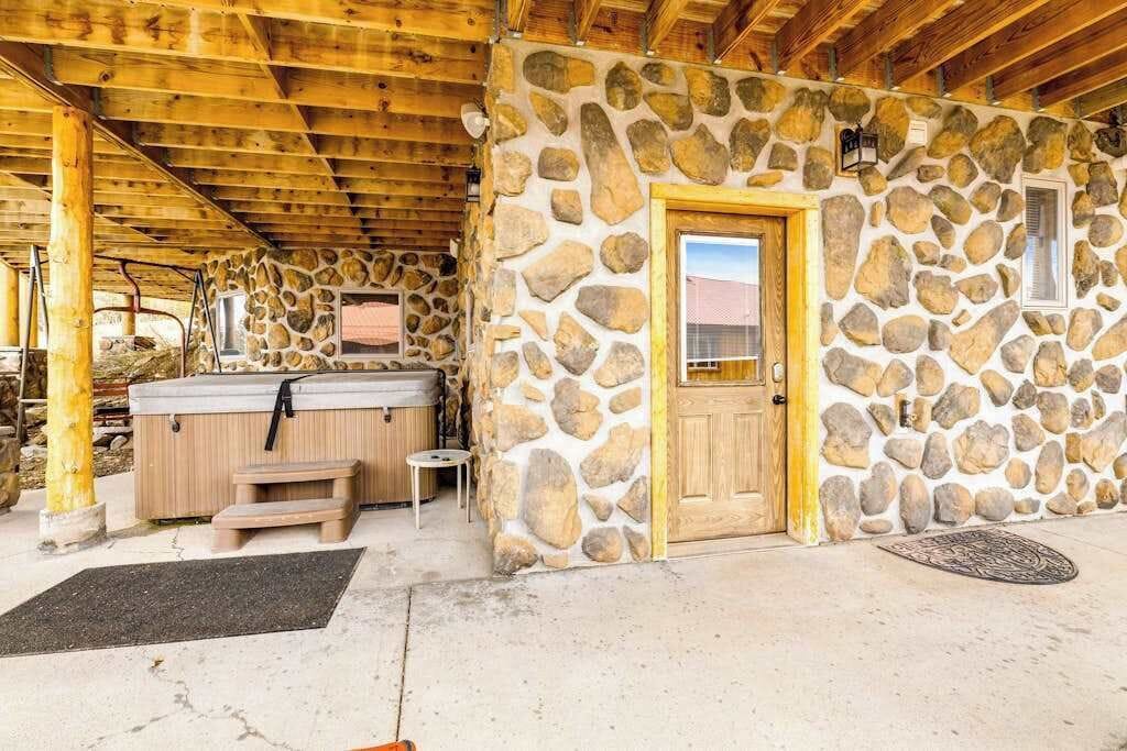 Un edificio de piedra con puerta de madera y un jacuzzi.