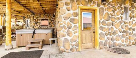 Un edificio de piedra con puerta de madera y un jacuzzi.